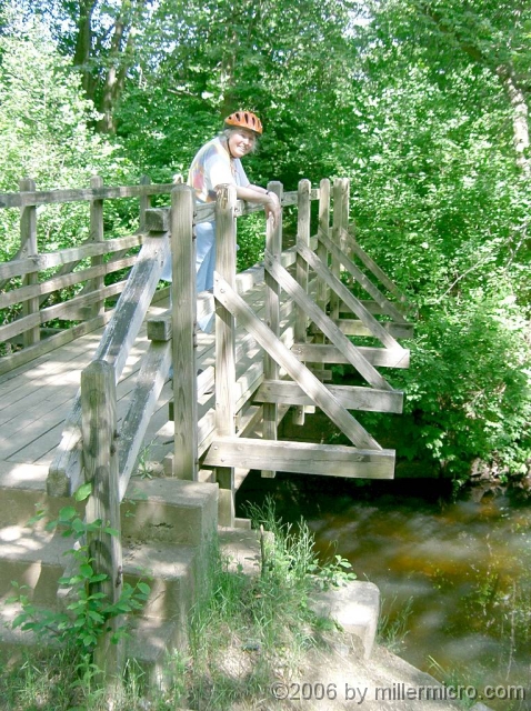 040605JillOnCRTBridge A little east of the CRT and south of Old Connecticut Path, Framingham's Cochituate Brook Reservation includes this lovely bridge at the site of a once-busy mill dam. There's trout in that brook.