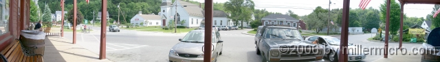 060630NewBostonNHpanorama We sat here, on the front porch of that general store, to eat our lunch. This panorama view (stitched from six hand-held photos, using PhotoSuite 7) shows some of this lovely village center. Note the town common on the left and, on the right between the town library and the river, an old, red sawmill.
(HINT: Tap the Z-key twice for full Zoom. Tap Z-key twice for full Zoom. When this image fills the window vertically, use the left- and right-arrow keys or slide the scroll button to scan across the full-sized panoramic image.)